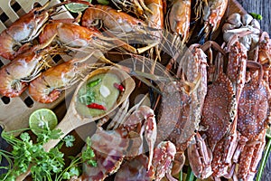 Closeup Thai Seafood platter lunch in Thailand Summer vacation. Whole crab and prawns bbq served with Thai seafood dipping spicy