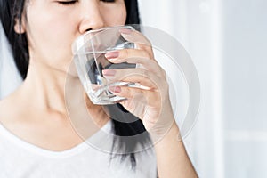 Closeup thirsty Asian woman drinking water glass