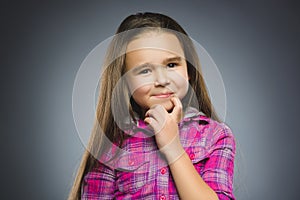 Closeup Thoughtful or contemptuous girl with hand on glasses Gray