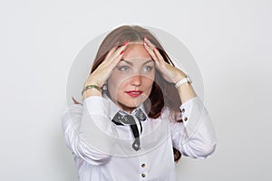 Closeup of a thoughtful red-haired woman with hands on forehead looking away isolated