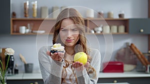 Closeup thoughtful woman looking at creamy dessert and fresh apple in kitchen