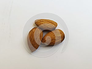 Closeup of three Almond Nuts isolated in a white background