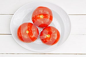 Closeup three red ripe wet tomatoes with water droplets