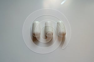 Closeup of three white caplets of kelp dietary supplement