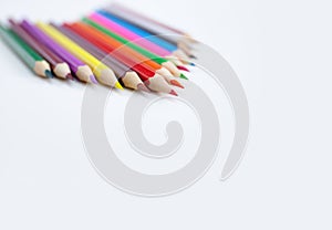 Closeup tips of colorful pencils on white background with copy space