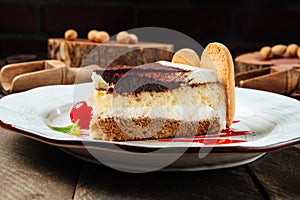 Closeup on tiramisu cake with berry sauce