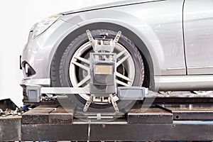 Closeup of tire clamped with aligner undergoing auto wheel align