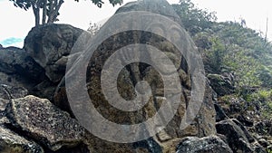 Closeup to an ancient petroglyph knowed as `la chaquira`. A human form with gigant eyes at Colombian San Agustin archaeological pa