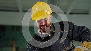 Closeup to the camera smiling large a construction worker man with safety helmet and uniform he working at construction