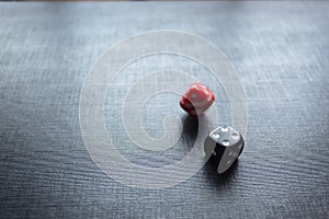 Closeup to a dices, one dice is black and one dice is spinning over a black background.