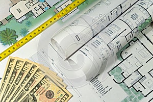 Closeup to floor plans, measuring yellow tape and US dollars. Architect drawings, expensive renovation,  building construction