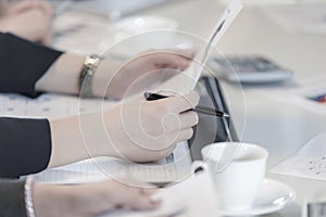 Closeup to hand business woman hold pen and financial document