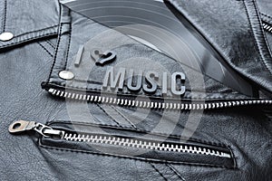 Closeup to a I hearth love 80 music lettering art over a black leather biker jacket with LP vinyl disc