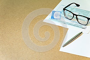 Closeup to Individual Income Tax Return Form 1040, social security card of USA,  glasses, ruler and pen located on the table with