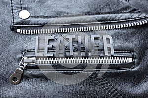 Closeup to a LEATHER lettering word over a black leather biker jacket