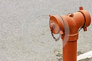 A closeup to a red fire hydrant water pipe near the road.