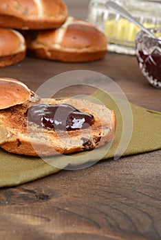 Closeup toasted hot cross bun with jam
