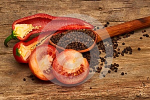 Closeup Tomaten, Red hot chili peppers and black pepper whole in wooden spoon on old wooden background