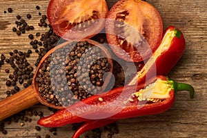 Closeup Tomaten, Red hot chili peppers and black pepper whole in wooden spoon on old wooden background