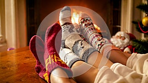 Closeup toned image of family in knitted socks warming by the fireside on Christmas eve