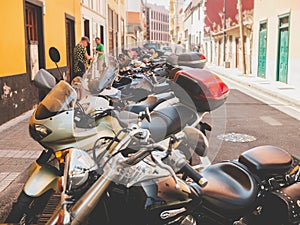 Closeup toned image of long row of parked scooters and motorcycles on city street