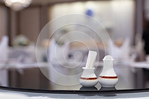 Closeup of toothpick holder and pepper pot on Chinese dinner table in a restaurant, selective focus