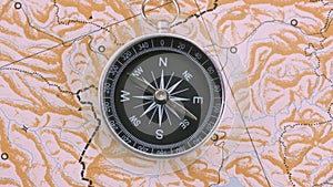 Closeup top view compass rotating on blank map