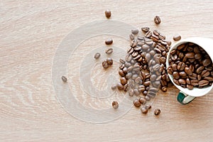 Closeup top view of many coffee beans in the ceramic mug with copy space for adding some text