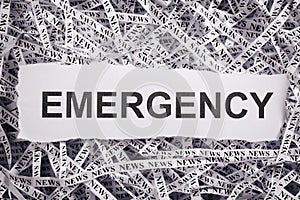 Closeup torn pieces and tapes of paper with the word EMERGENCY.