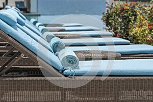 Closeup of towels on lounge chairs near a luxury swimming pool at a tropical resort spa in island Zanzibar, Tanzania, East Africa