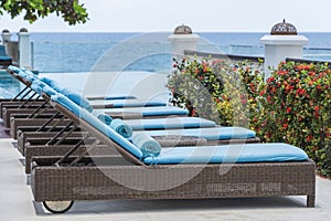 Closeup of towels on lounge chairs near a luxury swimming pool at a tropical resort spa in island Zanzibar, Tanzania, East Africa