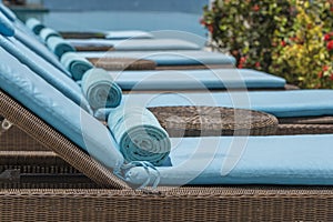 Closeup of towels on lounge chairs near a luxury swimming pool at a tropical resort spa in island Zanzibar, Tanzania, East Africa