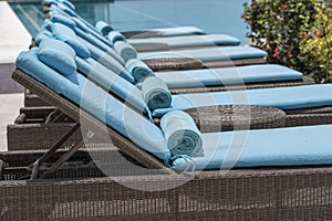 Closeup of towels on lounge chairs near a luxury swimming pool at a tropical resort spa in island Zanzibar, Tanzania, East Africa