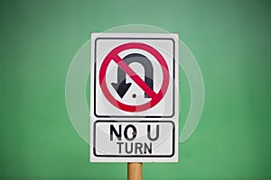 Closeup of a toy & x22;NO U TURN& x22; sign against a green background