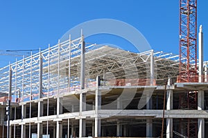 Closeup of Trade Center building during construction with steel frame shown against blue sky background. Retail shopping center