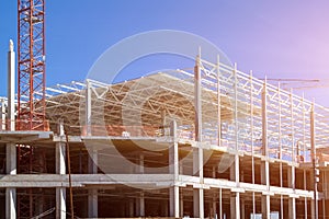 Closeup of Trade Center building during construction with steel frame shown against blue sky background. Retail shopping center