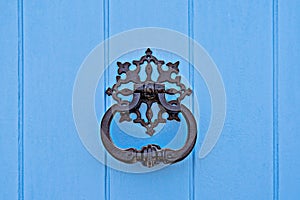 Closeup of traditional maltese door beater on blue door