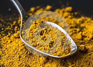 Closeup of tumeric powder spice on a spoon