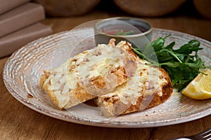 Closeup of a tuna melt topped with cheddar cheese