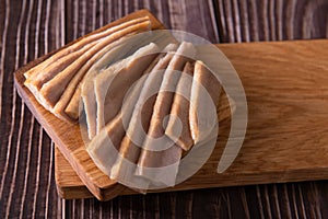 Closeup tuna slices on cutting board on wooden background top view