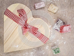 Closeup of turkish delight with a heart shaped gift box tied wi