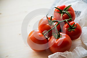 closeup twig five red tomatoes background wooden table