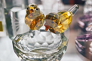 Closeup of two arti-crafts birds made of glasses sitting on the nest. Birds toy for children or decoration photo