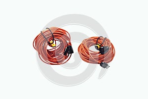 Closeup of two coiled extension cords with socket and plug on a white background