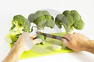 Fresh broccoli with scared cartoon style faces on white background