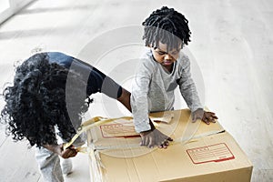 Closeup of Two kids helping unpack stuff together