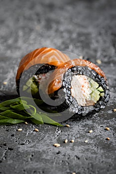 Closeup of two maki sushi rolls with black rice and sesame.