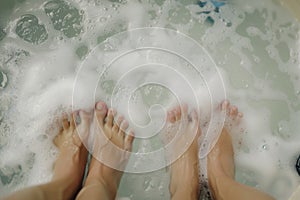 closeup on two sets of feet facing each other in a bubbly hot tub