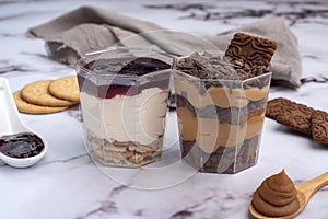 Closeup of two trifles with other desserts on a white table