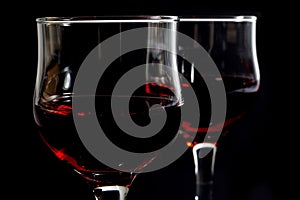 Closeup of Two Wineglasses Filled With Red Wine on Black
